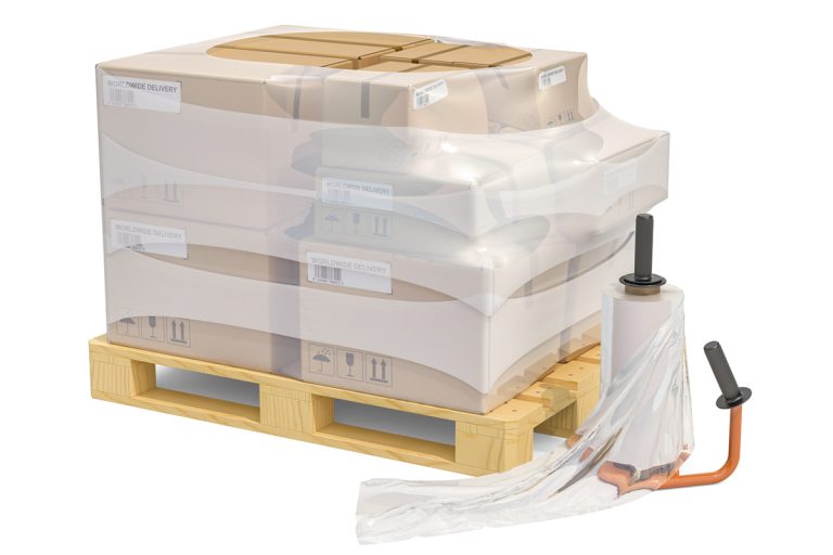 Manual film stretch wrapping machine and wooden pallet with parcels wrapped in the stretch film