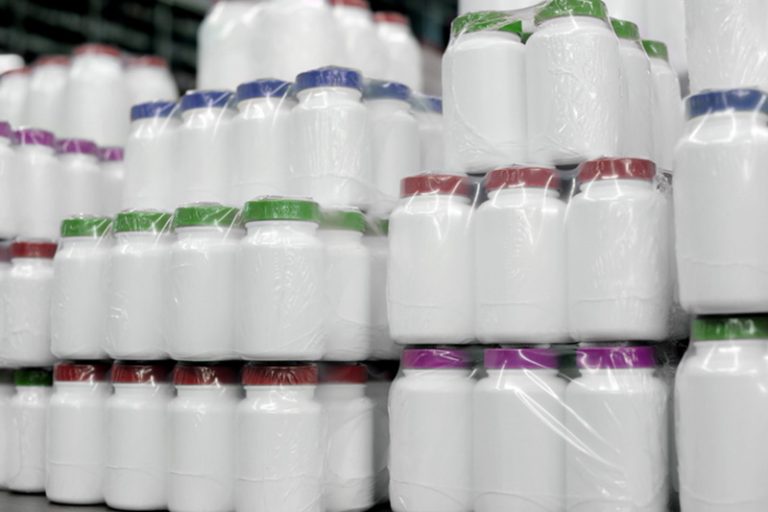 Shot of stacks of unlabeled drug bottles with different colored bottle caps.