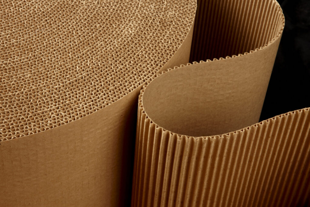 close up shot of Single Face Rolls corrugated packing material uncurling on black background