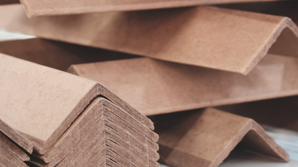 Stack of cardboard corner protectors for packaging, corners are brown and arranged in a row as background templates of pages and banners of delivery logistics concept
